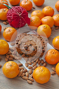 Christmas cake on a table with almonds, mandarins