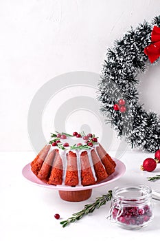 Christmas cake topped with sugar icing, cranberry and rosemary