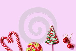 Christmas candies and sweets on a pink background.