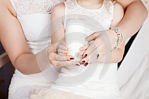 Christmas candle. Christmas decor. Hands of mother and daughter holding burning  candle.Happy family concept