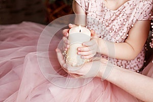 Christmas candle. Christmas decor. Hands of mother and daughter holding burning  candle.Happy family concept. Copy space