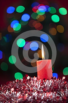 Christmas candle with colorful lights background