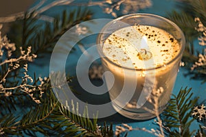 A Christmas candle with decorative golden stars