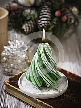 Christmas Candle. New Year's composition with candle in the shape of a Christmas tree. Burning wax candle in shape