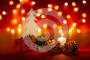 Christmas candle and ornaments over dark background with lights