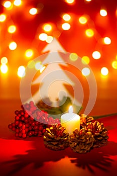 Christmas candle and ornaments over dark background with lights