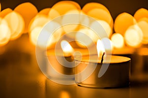 Christmas candles burning at night. Abstract candles background. Golden light of candle flame.