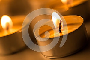 Christmas candles burning at night. Abstract candles background. Golden light of candle flame.