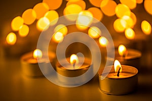 Christmas candles burning at night. Abstract candles background. Golden light of candle flame.