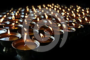 Christmas candles burning at night. Abstract candles background. Golden light of candle flame.