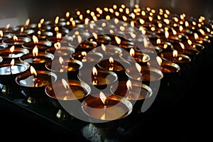 Christmas candles burning at night. Abstract candles background. Golden light of candle flame.