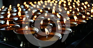 Christmas candles burning at night. Abstract candles background. Golden light of candle flame.