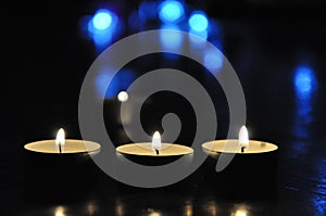 Christmas candles burning at night.  Golden light of three candle flame. Decoration,abstract candles background.