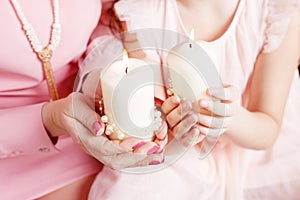 Christmas candles. Christmas decor. Hands of mother and daughter holding burning  candles.  Happy family concept