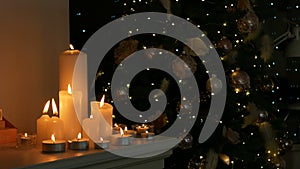 Christmas candles and decorations on a background with lights on the Christmas tree.