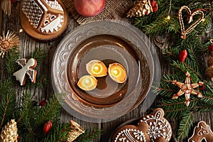Christmas candles made of bees wax and walnut shells floating in a bowl of water, top view