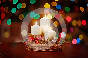 Christmas candles and ornaments over dark background  of de-focused lights