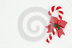 Christmas candy cane with a bow on white chevron textured fabric background