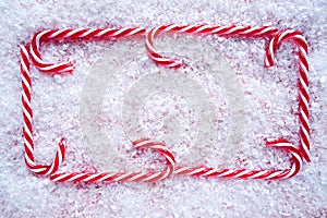 Christmas candy cane frame on snow