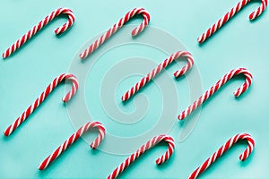 Christmas candy cane lied evenly in row on blue. Flat lay and top view