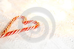 Christmas candy cane striped Santa in the form of heart on a white knitted blanket. A symbol of love, a gift to a loved one, a swe