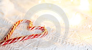 Christmas candy cane striped Santa in the form of heart on a white knitted blanket. A symbol of love, a gift to a loved one, a swe