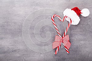 Christmas candy canes, stick and decor on color background. Christmas candy cane heart on an red background