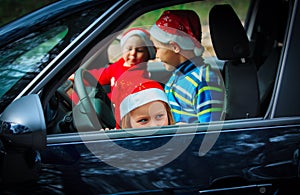 Christmas car travel- happy kids travel by car in winter