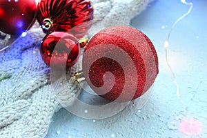 Christmas card. Beautiful Christmas background. Lots of red balls big and small on blue texture background. White snowflakes circl
