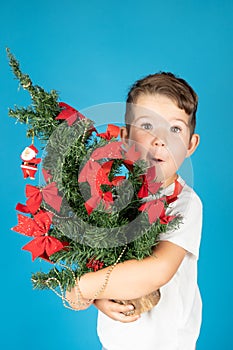 Christmas card. Beautiful smiling little boy holding christmas tree
