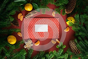 Christmas card. Composition from Christmas decorations, orange and gift, fir branches on a red background. Flat lay, top