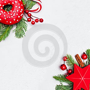 Christmas card composition with red star, donut, green Xmas fir branch, red holly berries and baubles on white background