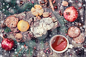 Christmas card. Cookies Chocolate, tea, pomegranate, Tangerines, Nuts, cocoa beans, Fir branches on wooden background.