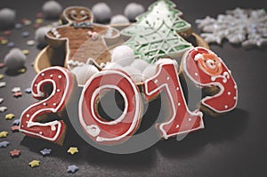 Christmas card on dark background gingerbread red numbers 2019 with slices of orange, multi-colored stars and gingerbread Man