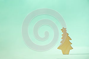 Christmas card with decorative wooden Christmas tree on blue background. New Year holiday concept in minimal style. Copy space