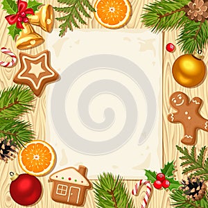 Christmas card with fir branches, balls and cookies on a wooden background.