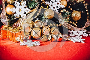 Christmas card with fir tree branch decorated with golden baubles, garlands and vintage snowflakes on a red background.