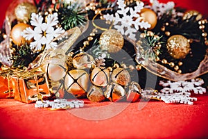 Christmas card with fir tree branch decorated with golden baubles, garlands and vintage snowflakes on a red background.