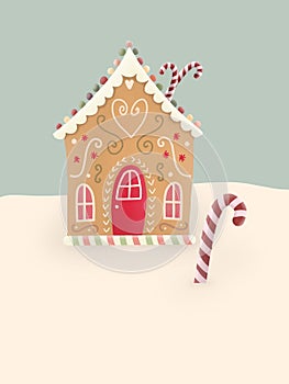 Christmas card with gingerbread house in snow. A few sugar canes.