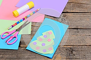 Christmas card guide. Step. Paper Christmas greeting card, pencil, glue stick, colored paper, scissors on wood background