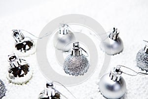 Christmas card, illustration with golden baubles, balls, decorations, ornaments on a silver white background with blurry, blurred