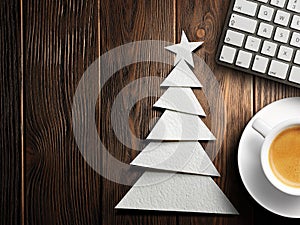 Christmas card. Keyboard, cup of coffee and Christmas tree made of paper