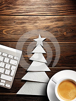 Christmas card. Keyboard, cup of coffee and Christmas tree made of paper