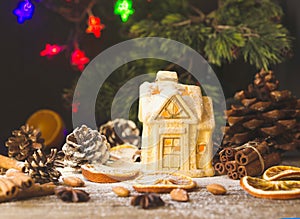 Christmas card with little toy house and decorations on a wooden rustic table, selective focus