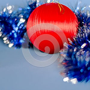 Christmas card: A red Christmas tree toy lies on a blue background