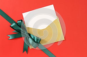 Christmas card, red gift paper background, green ribbon bow diagonal, white copy space