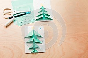 Christmas card, a stack of colored paper of different sizes, scissors and glue