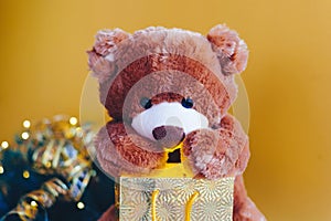 Christmas card with Teddy Bear opening gift and holiday decoration