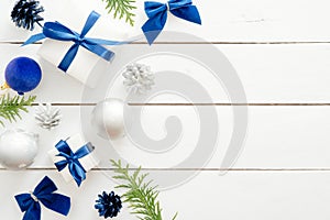 Christmas card template with blue balls, gift boxes, ornaments on wooden white background. New year holiday festive banner mockup