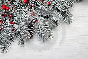 Christmas card. White wooden background with snow fir tree and decoration. Top view with copy space for your text